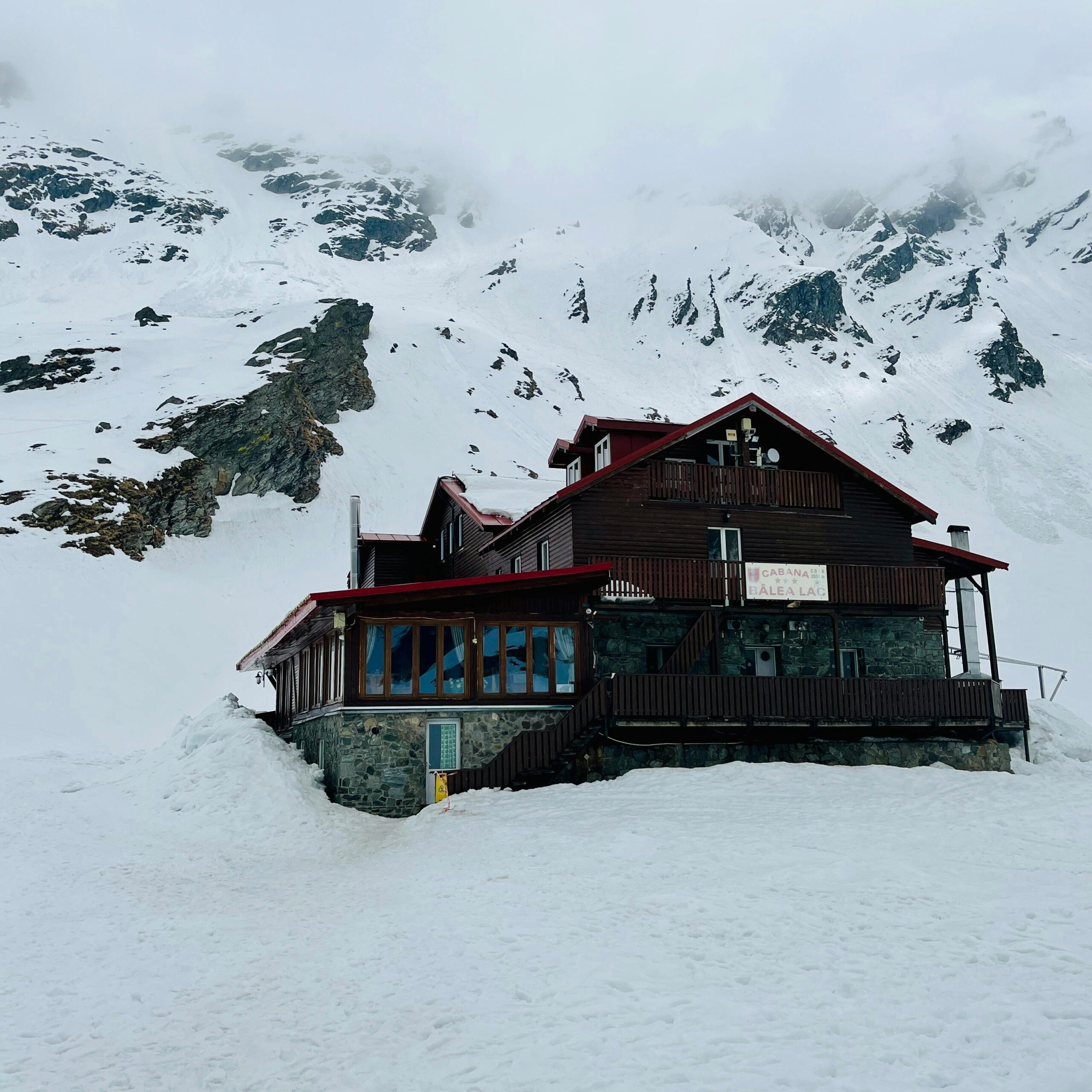 A scenic view of a mountain lodge surrounded by pristine snow, offering winter retreat.