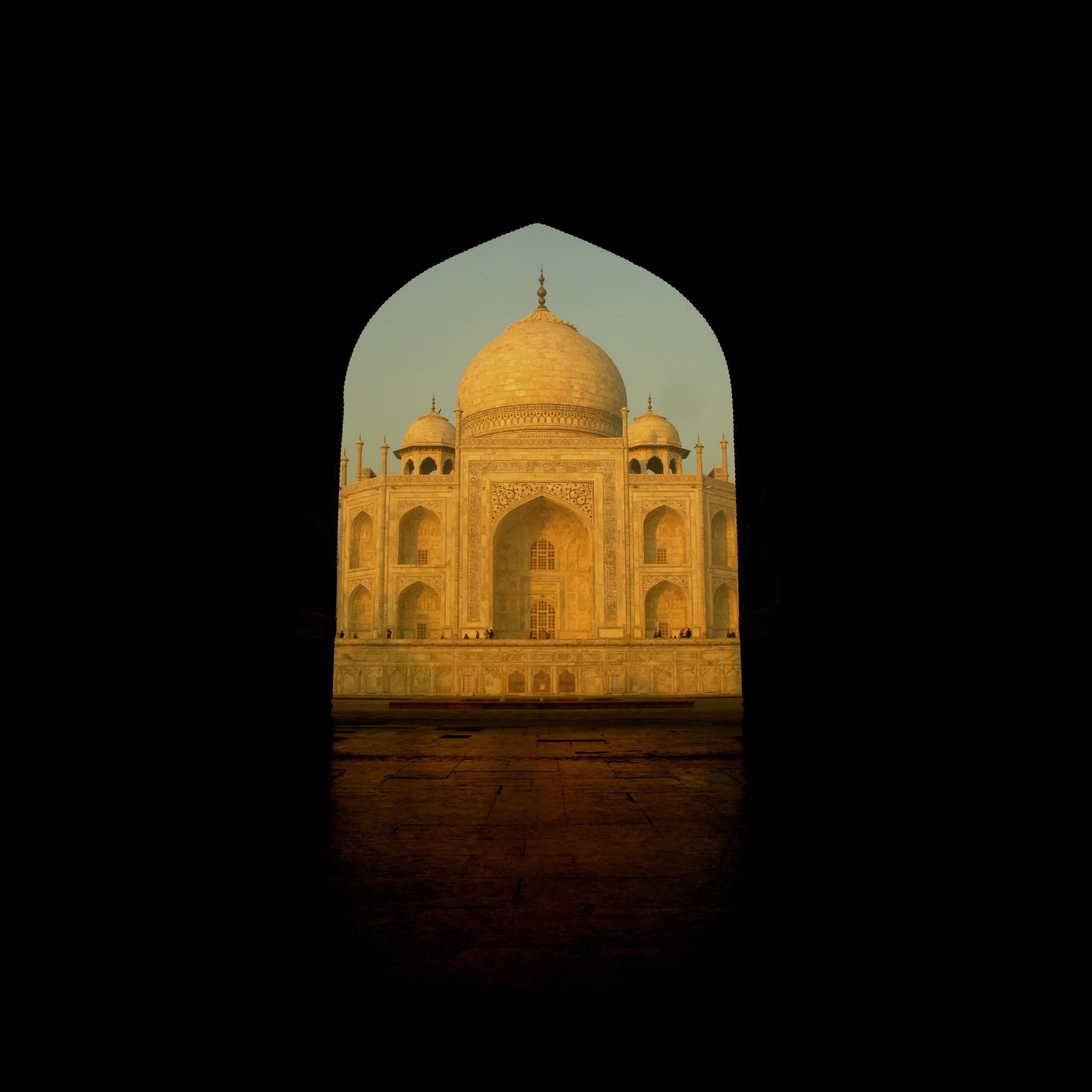 Beautiful architectural frame of the iconic Taj Mahal at sunrise.