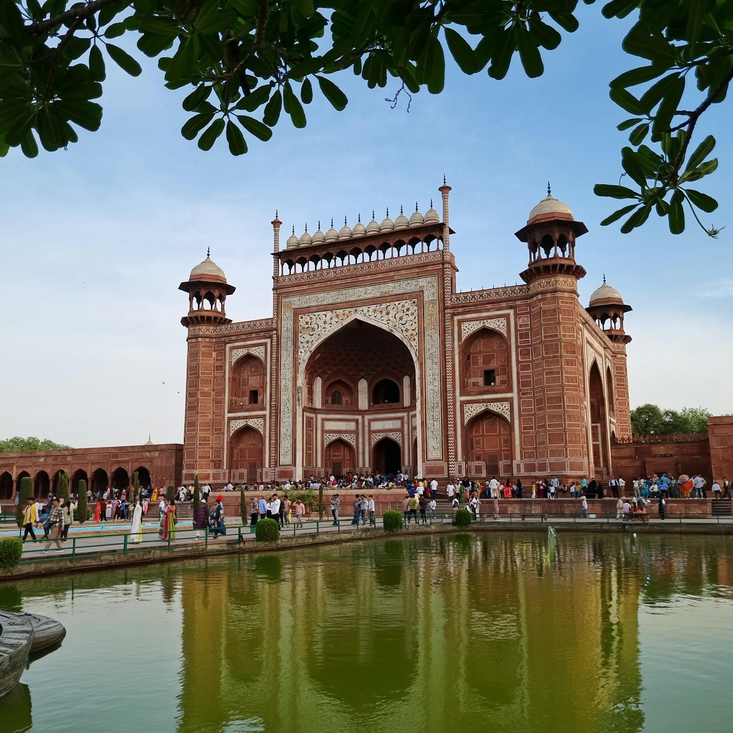 The iconic entrance gate of Red Fort in Agra, India, on a sunny day with tourists.